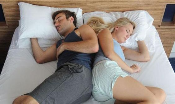 Postura de dormir de espaldas tocándose en pareja